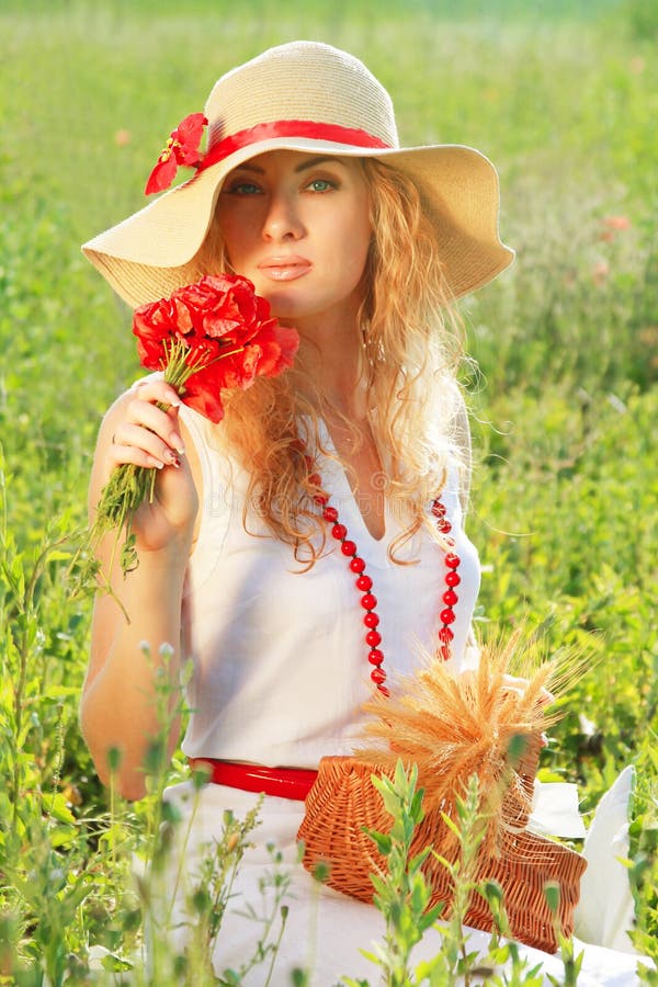 Woman in hat with poppy bouquet