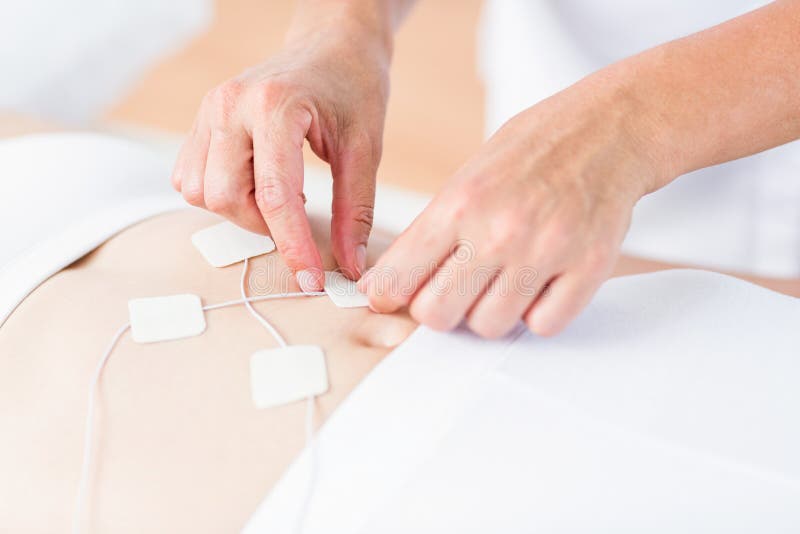 Female Doctor with Senior at Electrotherapy for Pain Relief Stock