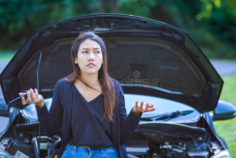A woman headache while looking at broken down car on road royalty free stock photo A woman headache while looking at broken down car on road royalty free stock photo