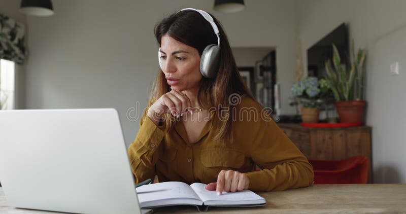 Woman writing in personal organizer, studying or working using videocall stock footage