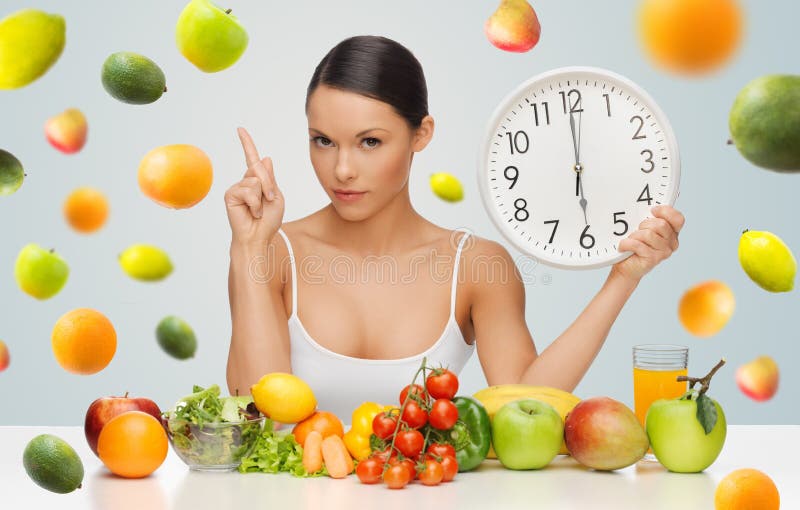 Woman with healthy food and clock warning royalty free stock photo Woman with healthy food and clock warning royalty free stock photo