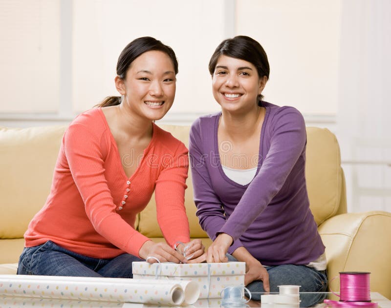 Woman helping friend wrap birthday gift. Woman helping generous friend wrap birthday gift stock photos Woman helping friend wrap birthday gift. Woman helping generous friend wrap birthday gift stock photos