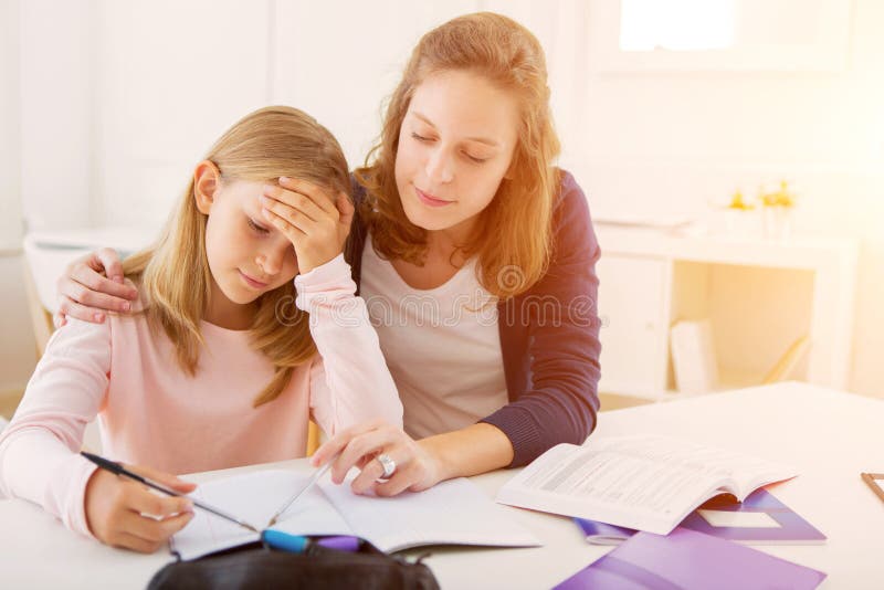 Woman helping out her little sister for homework.