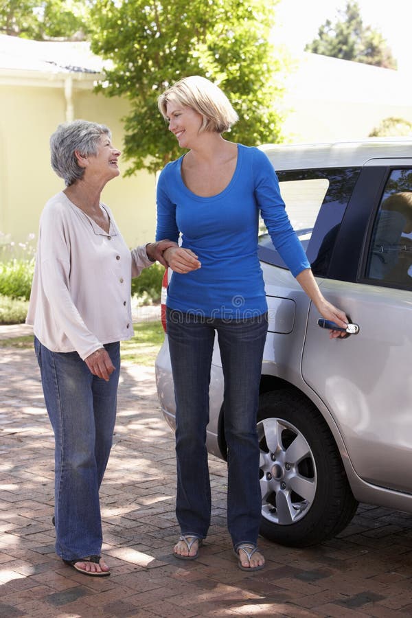 Woman Helping Senior Woman Into Car stock image Woman Helping Senior Woman Into Car stock image