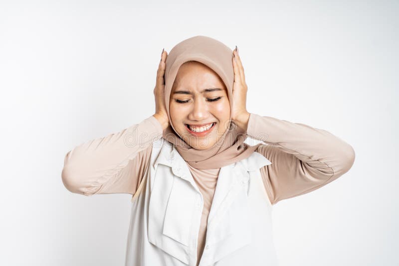 Woman in hijab holding head while confused by situation on isolated background cover her ear