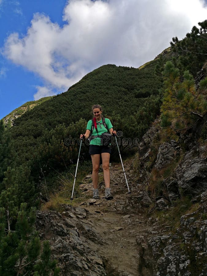 Woman hiker dressed in green descends a mountain. Rea trail stock images, royalty-free photos and pictures