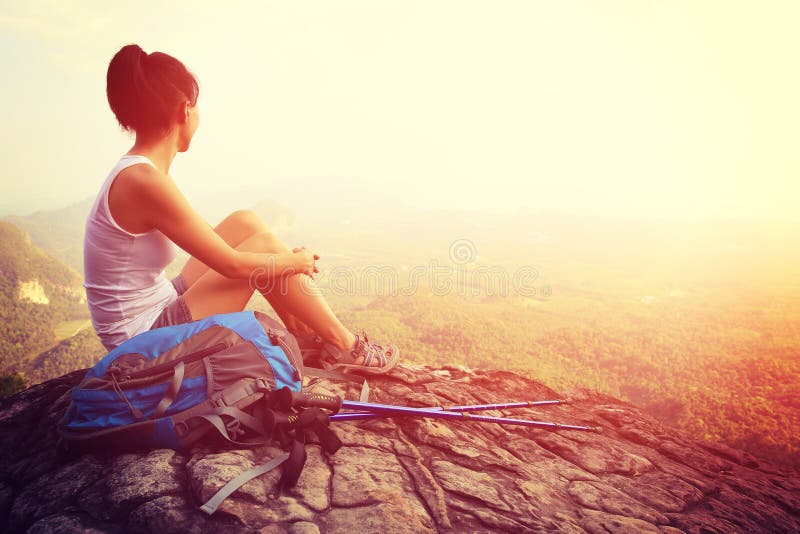 Woman hiker enjoy the view at mountain peak cliff stock photo Woman hiker enjoy the view at mountain peak cliff stock photo