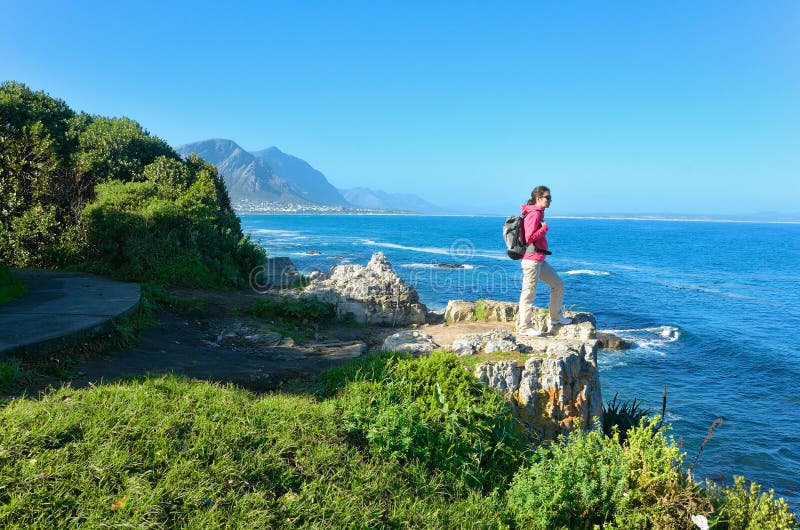 Woman hiking and looking at beautiful ocean view