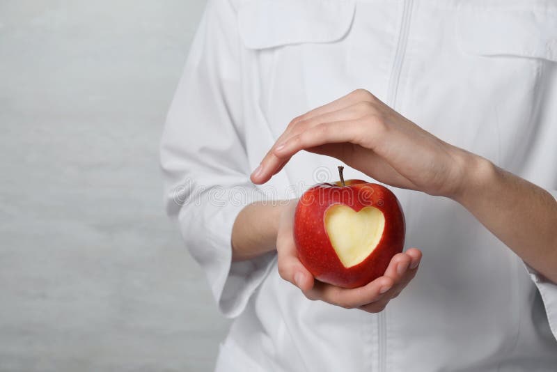 Woman holding apple with carved heart stock photos Woman holding apple with carved heart stock photos