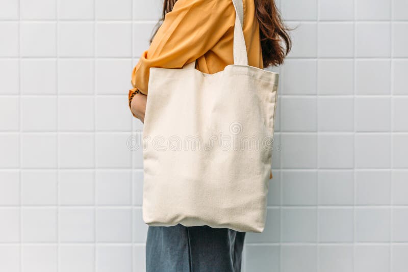 Woman is holding bag canvas fabric for mockup blank template