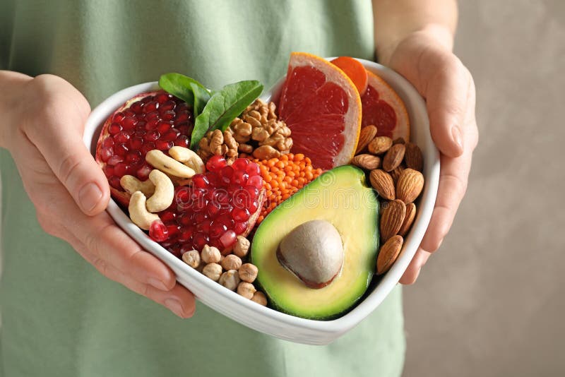 Woman holding bowl with products for heart-healthy diet