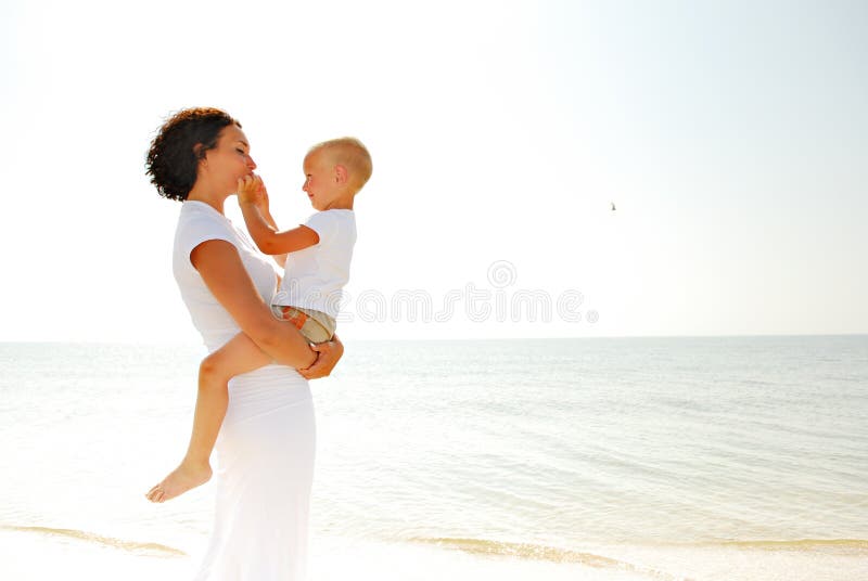 Woman holding boy on beach