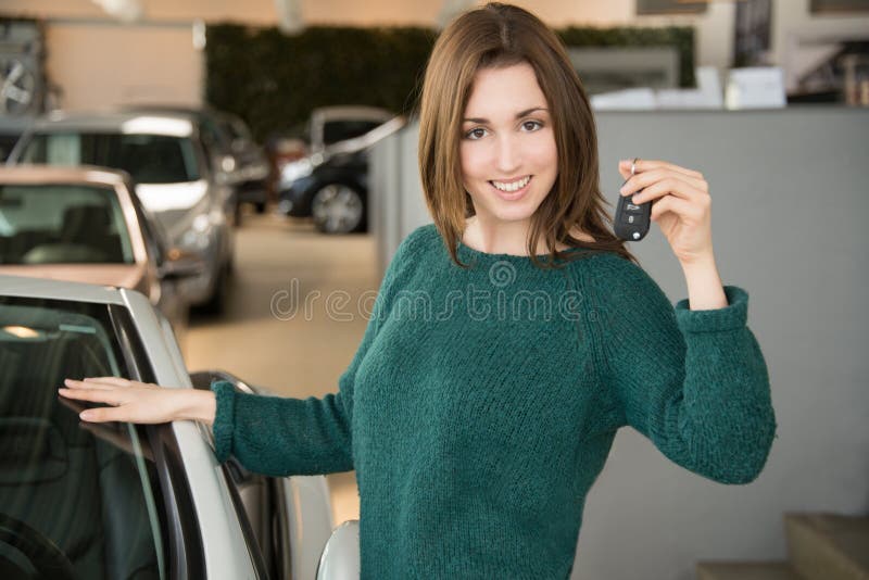 Woman holding car key inside car dealership stock photos Woman holding car key inside car dealership stock photos
