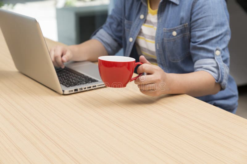 woman holding coffee cup with laptop computer for use as working concept