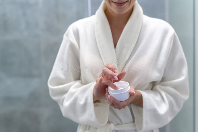 Woman holding cream in hands, standing at bathroom royalty free stock image Woman holding cream in hands, standing at bathroom royalty free stock image