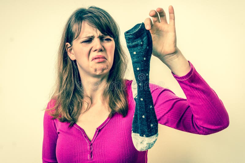Woman holding dirty stinky socks - retro style royalty free stock image Woman holding dirty stinky socks - retro style royalty free stock image