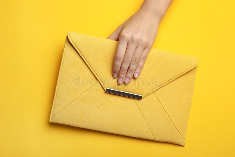 Woman Holding Envelope Bag on Yellow Background, Top View Stock Photo