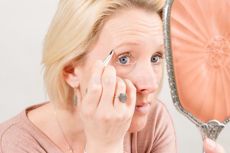 Woman Plucking Her Eyebrows In The Mirror Stock Image Image of