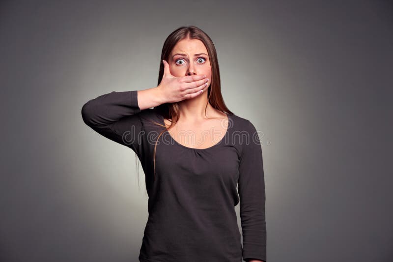 Woman holding hand over her mouth stock photos