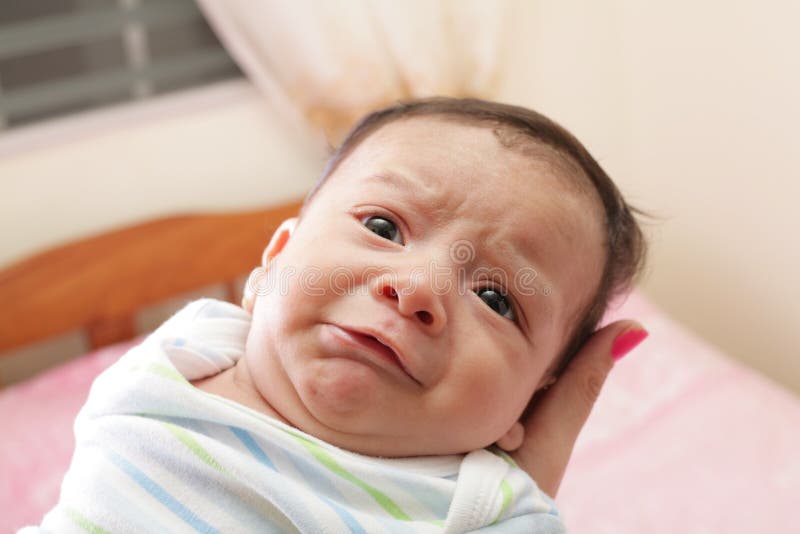 Woman holding a hispanic newborn crying stock photo Woman holding a hispanic newborn crying stock photo