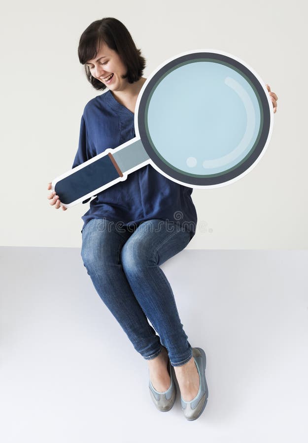 Woman holding magnifying glass icon stock photography