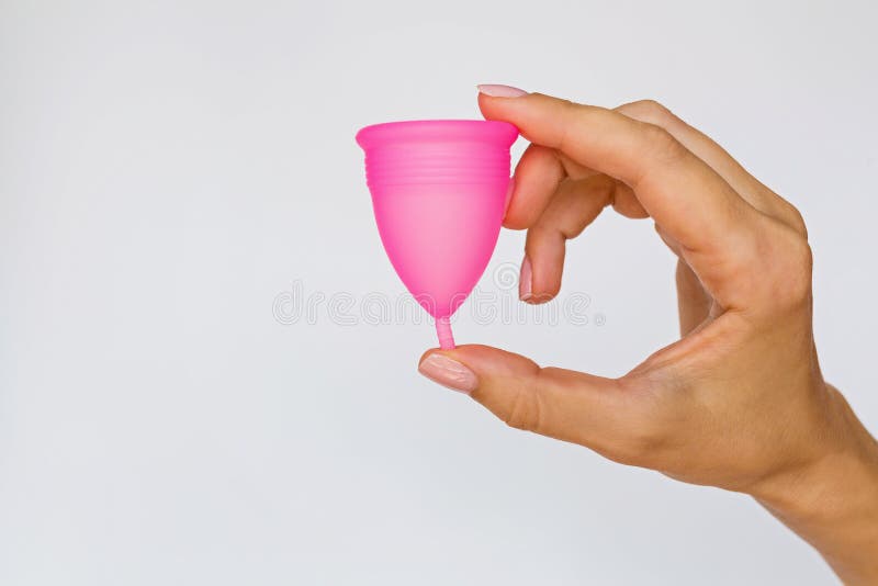 Woman holding menstrual cup on white background. Feminine hygiene alternative product instead of tampon during period. Woman hand holding menstrual cup on white royalty free stock images Woman holding menstrual cup on white background. Feminine hygiene alternative product instead of tampon during period. Woman hand holding menstrual cup on white royalty free stock images