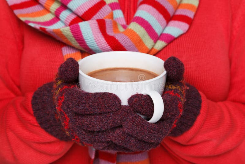 Close up midriff photo of a woman wearing a red jumper, woolen gloves and a scarf holding a mug full of hot chocolate, good image to convey a feeling of winter and warmth. Close up midriff photo of a woman wearing a red jumper, woolen gloves and a scarf holding a mug full of hot chocolate, good image to convey a feeling of winter and warmth.