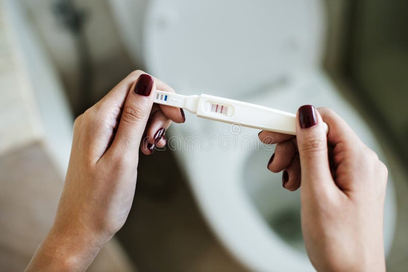 Woman holding a positive pregnancy test