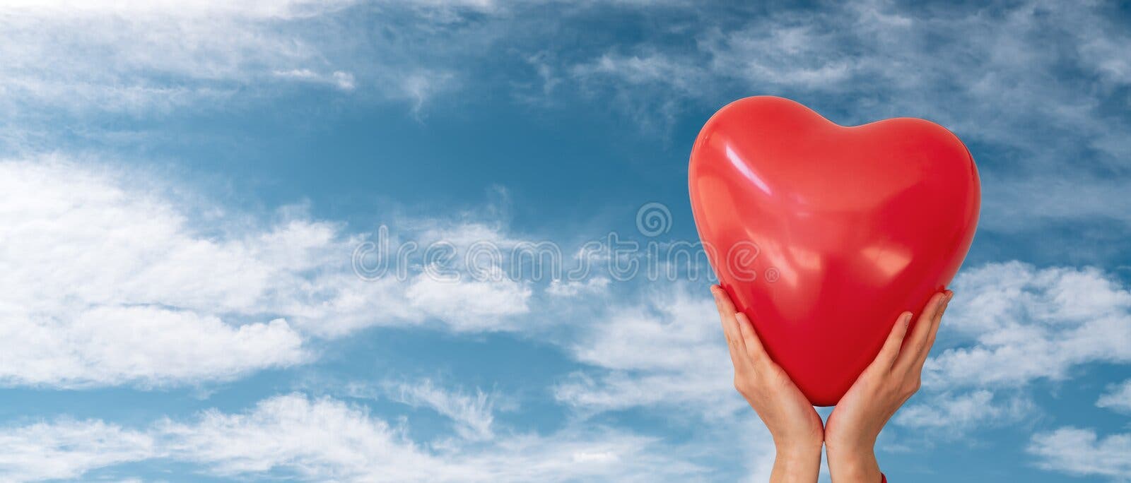 Woman is holding red heart shaped balloon to the cloudy blue sky background. Valentine day and romance concept. stock photos Woman is holding red heart shaped balloon to the cloudy blue sky background. Valentine day and romance concept. stock photos