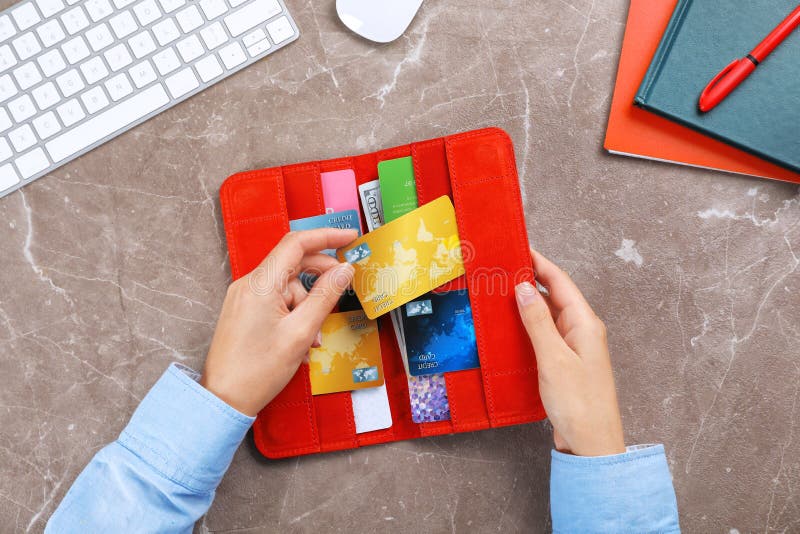 Woman holding red wallet with credit cards