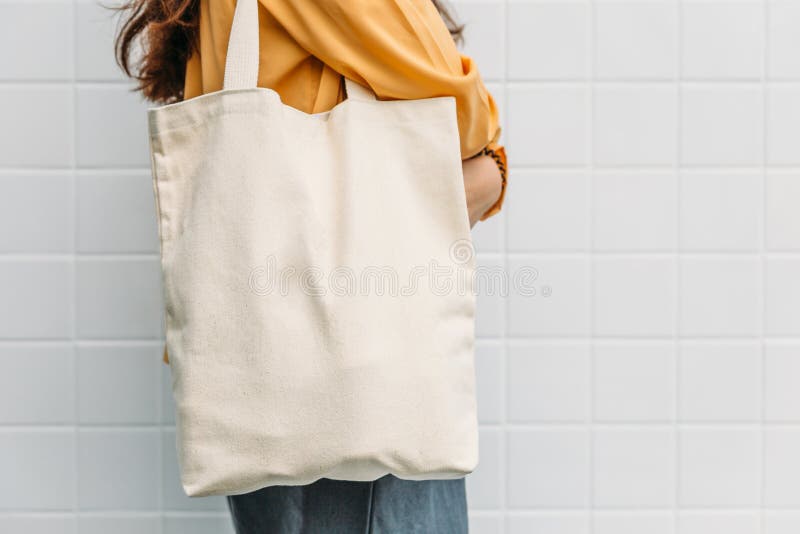 Woman is holding tote bag canvas fabric for mockup blank template