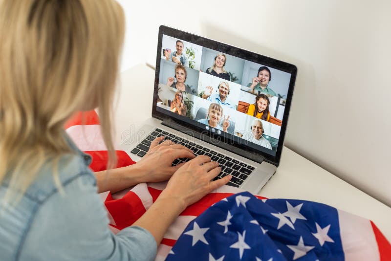 Woman holding usa flag and video by laptop