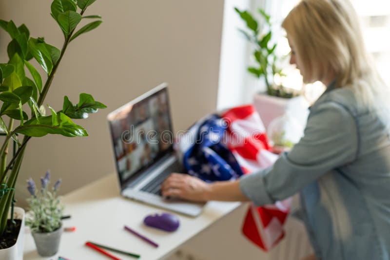 Woman holding usa flag and video by laptop