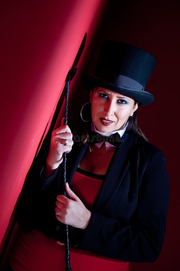 Woman holding whip and wearing top hat