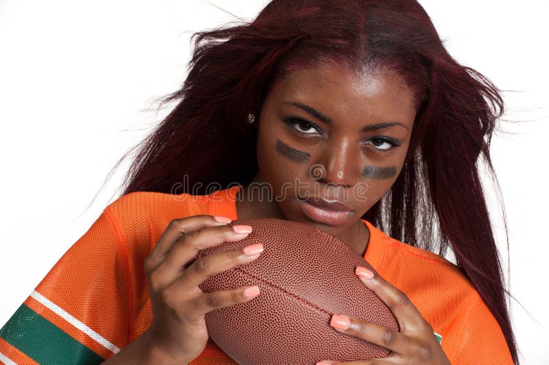 Portrait of young woman holding an american football ball. Portrait of young woman holding an american football ball.