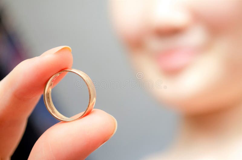 Woman holds a golden ring. Female finding ring. Golden ring close up photo. My precious. Find the lost. Hand hold ring. Smile woma
