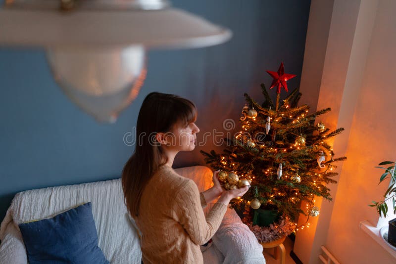 Woman holds in the hands of Golden Christmas tree toys. Winter holidays in a house interior. Golden and white Christmas royalty free stock photos Woman holds in the hands of Golden Christmas tree toys. Winter holidays in a house interior. Golden and white Christmas royalty free stock photos