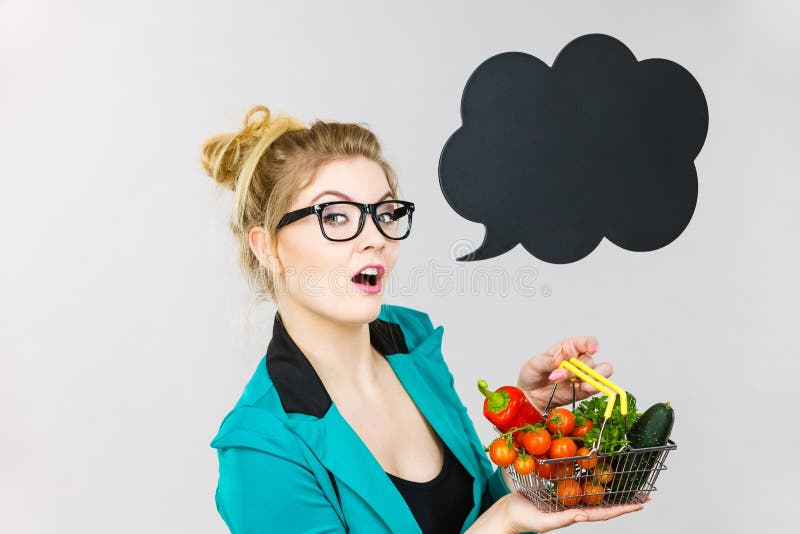 Woman holds shopping cart with vegetables, copy space stock photo Woman holds shopping cart with vegetables, copy space stock photo