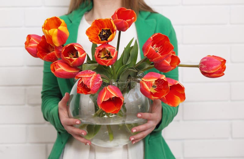 Woman holds a vase of tulips