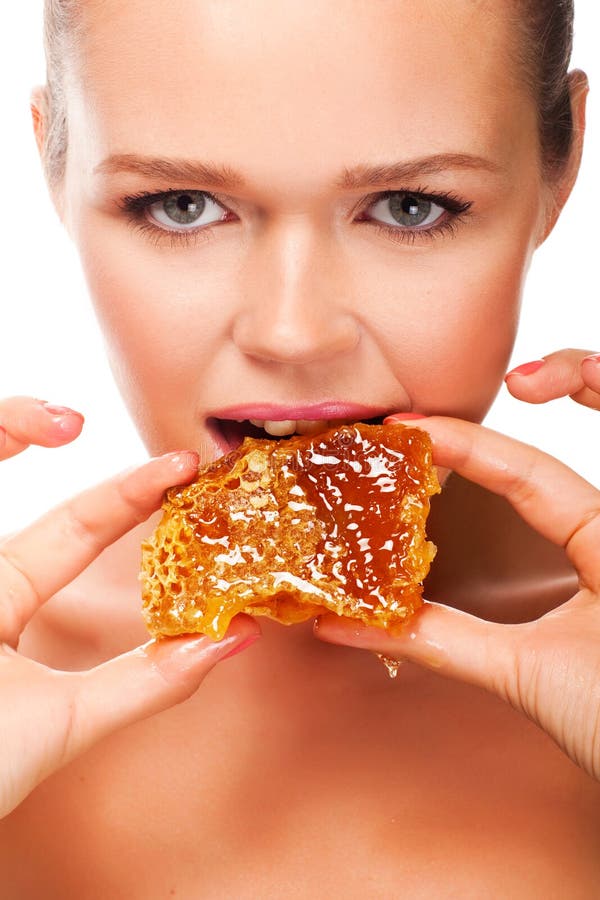 Attractive caucasian girl eating honey isolated on white background. Attractive caucasian girl eating honey isolated on white background