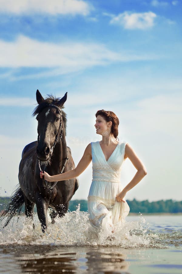 Immagine di una donna su un cavallo al mare.