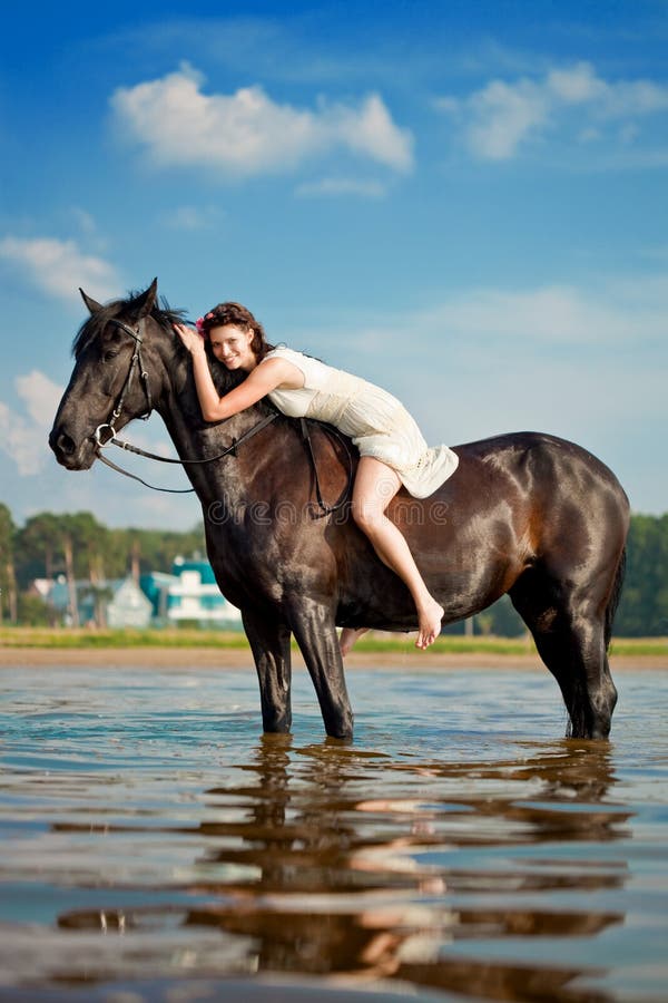 Immagine di una donna su un cavallo al mare.