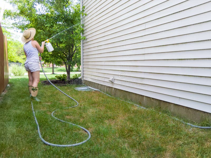 Woman hosing down the sides of her house royalty free stock photos Woman hosing down the sides of her house royalty free stock photos