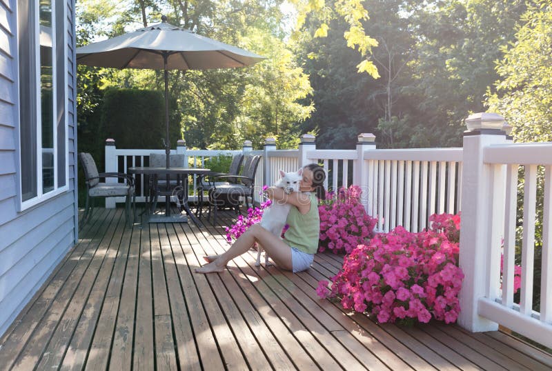 Woman hugging her dog while outdoors on home deck royalty free stock images Woman hugging her dog while outdoors on home deck royalty free stock images