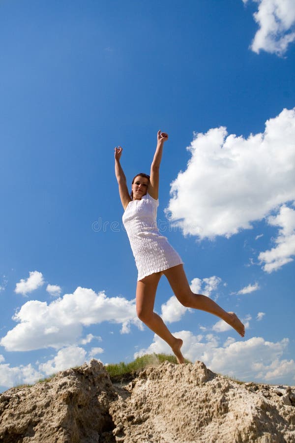 Woman jumping on blue sky background