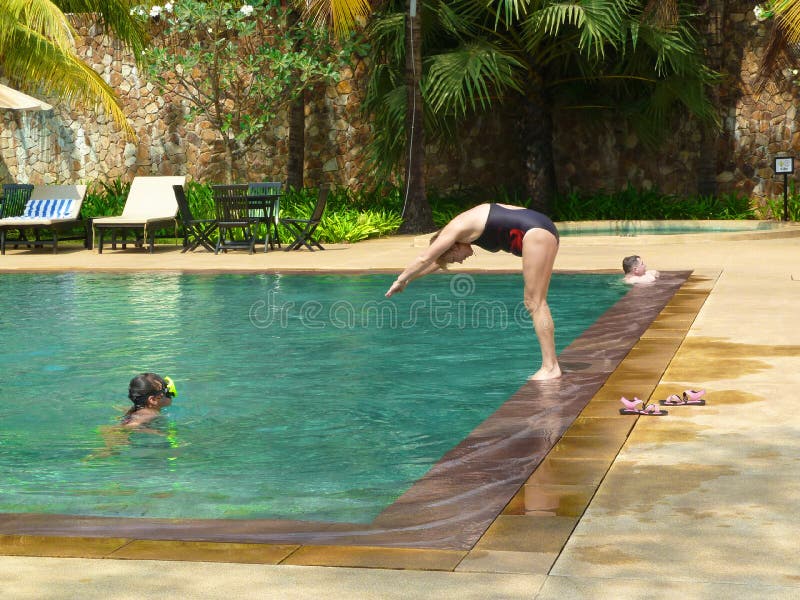 Woman jumping dives in hotel pool - Siem Reap, Cambodia 02/21/2011.