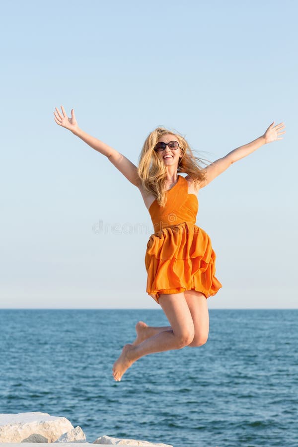 Woman jumping for joy at the sea