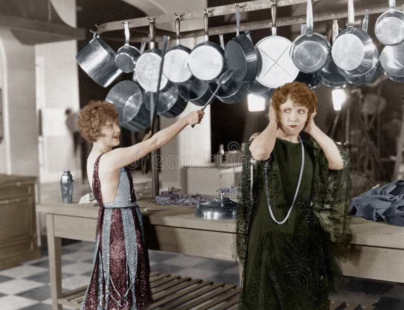 Woman in kitchen beating on pots and pans royalty free stock photography