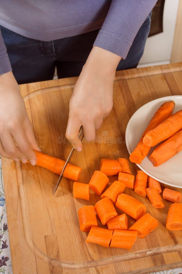 https://thumbs.dreamstime.com/b/woman-kitchen-cuts-carrots-pieces-knife-board-181743386.jpg