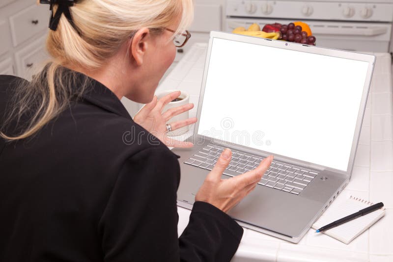 Woman In Kitchen Using Laptop with Blank Screen